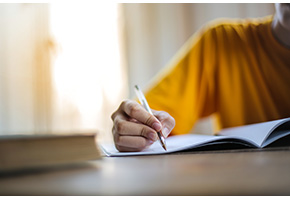 Student writing in a notebook